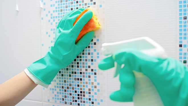 person cleaning showel wall with mould cleaner